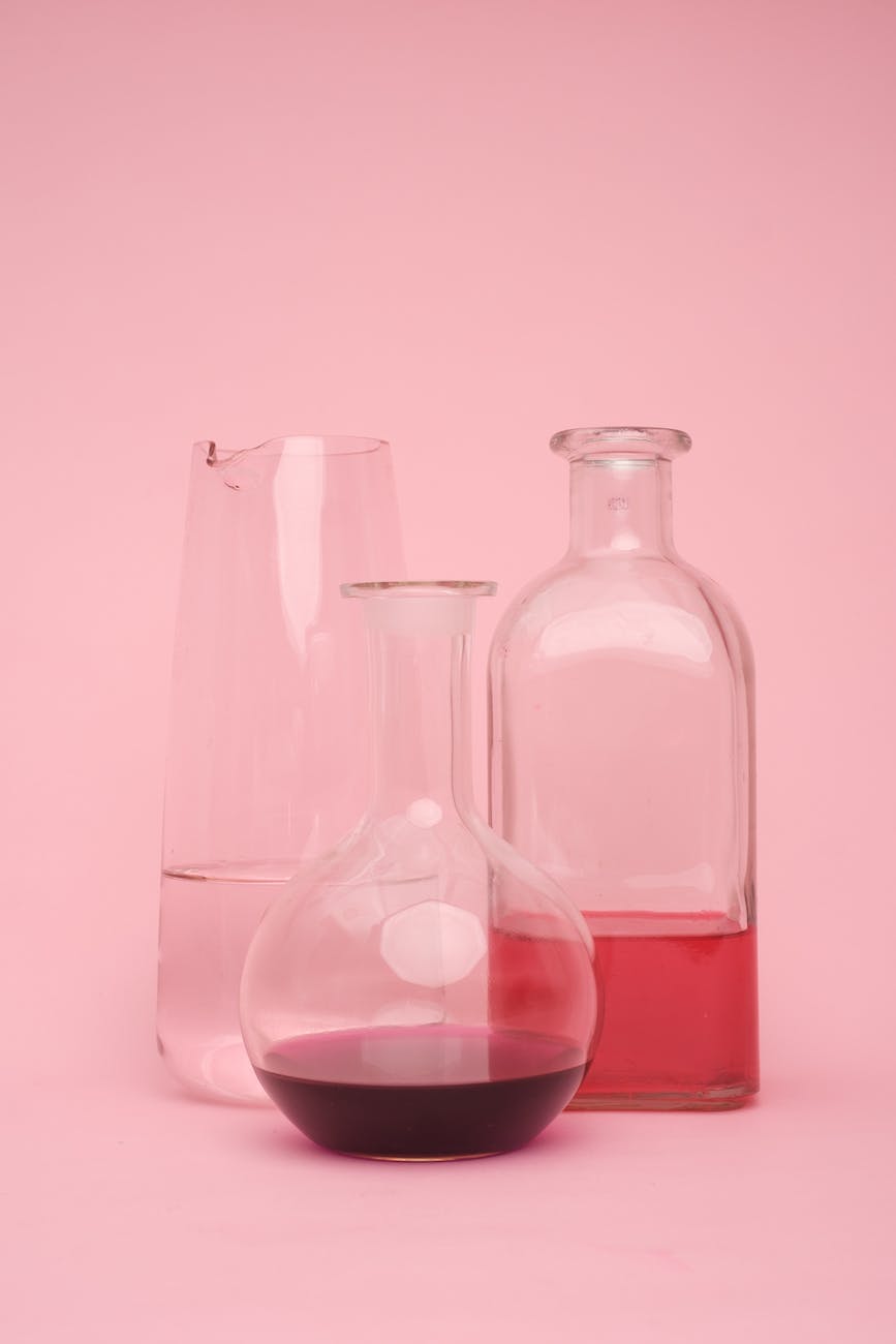 laboratory test tube with various liquids on pink surface