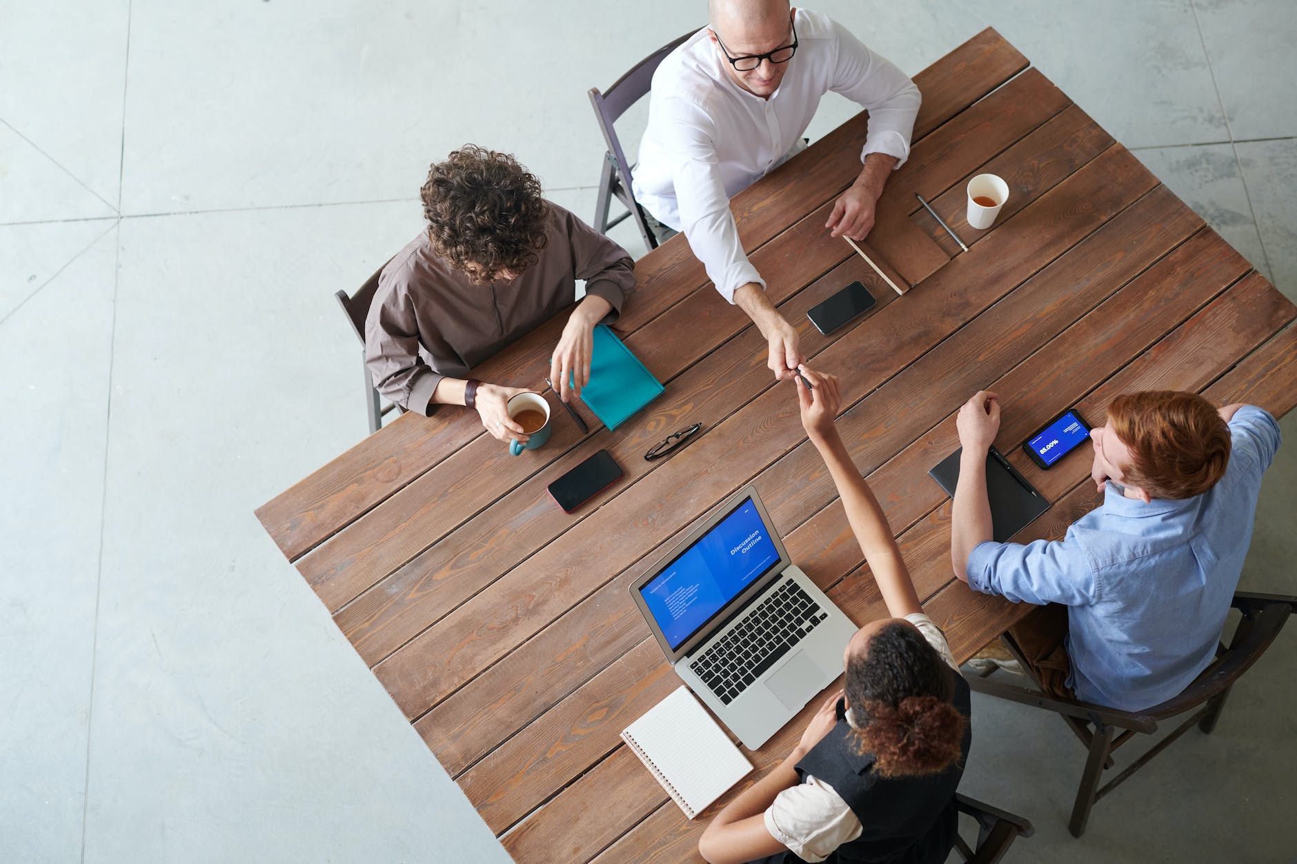 four people sitting beside wooden table