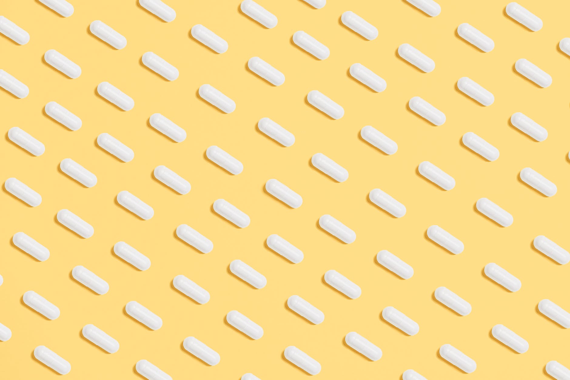 white capsules on yellow background