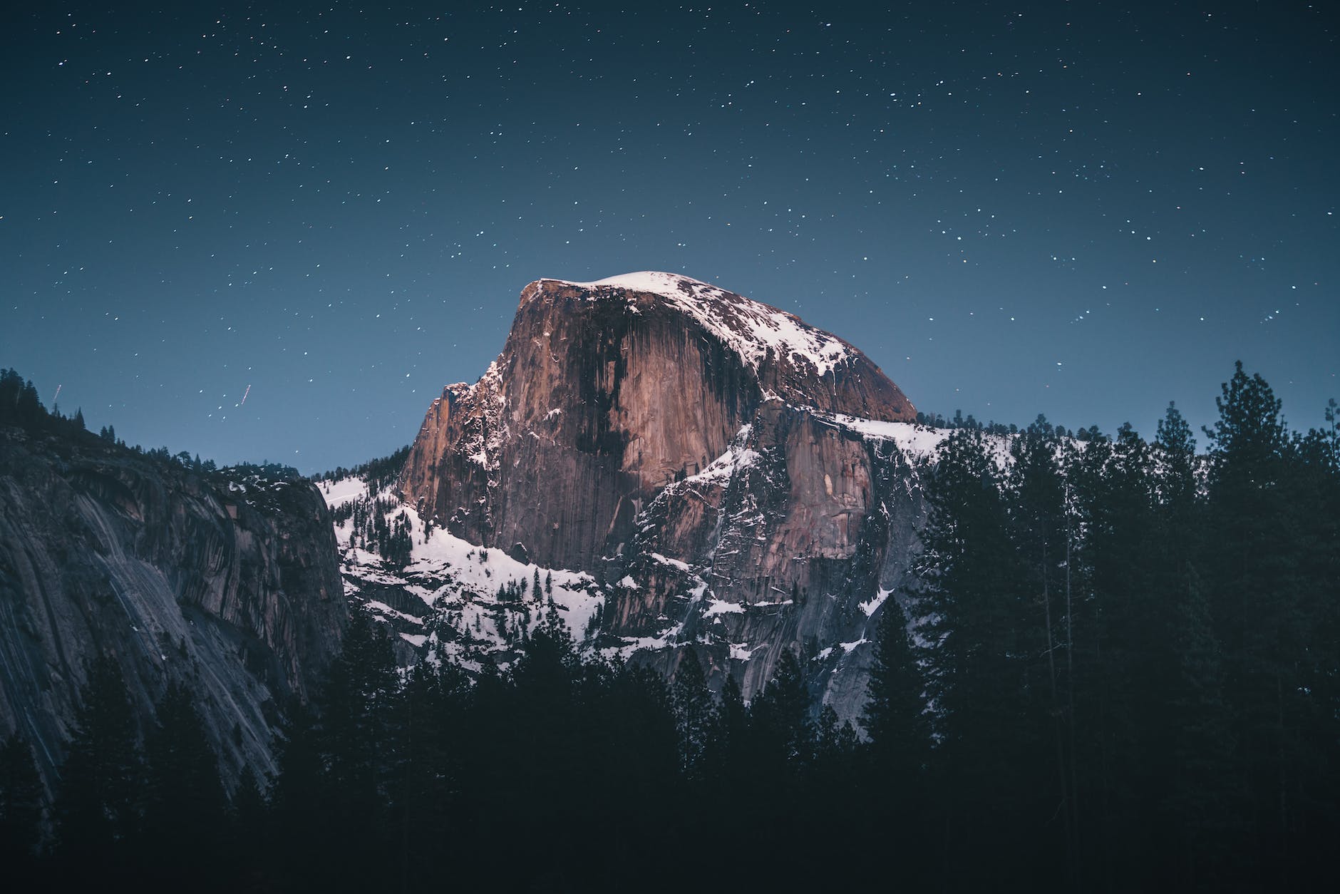 photo of snow capped mountain under blue night sky